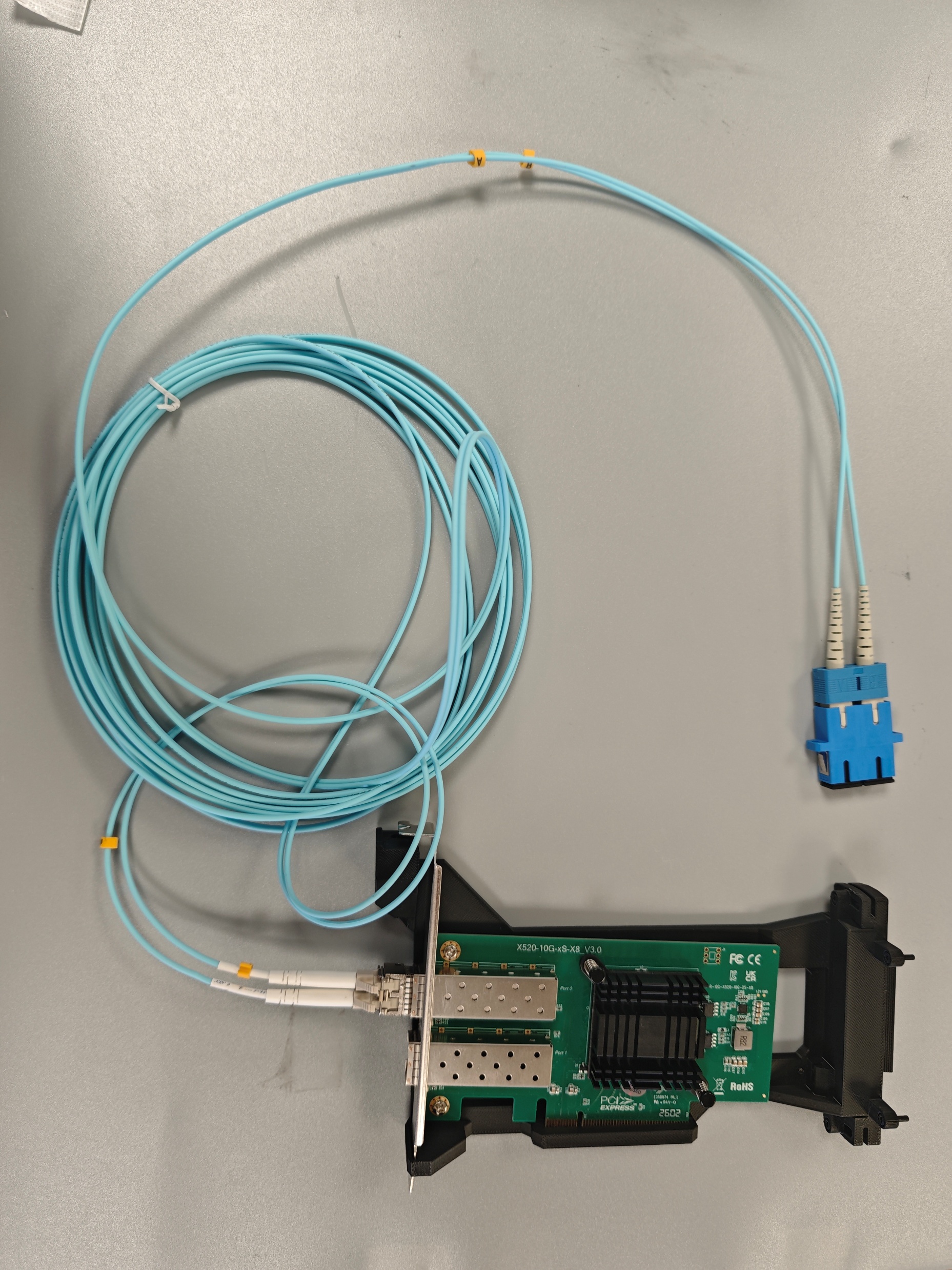 Optical cable with SC connectors and a network interface card prepared for experiments.